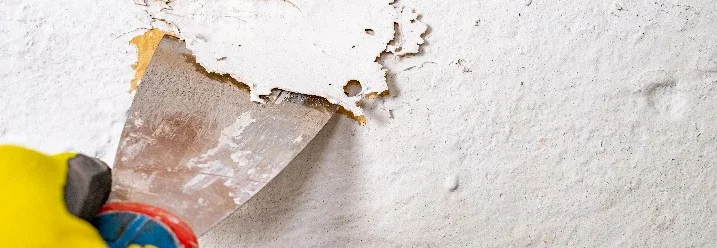 Hand entfernt Putz mit Spachtel